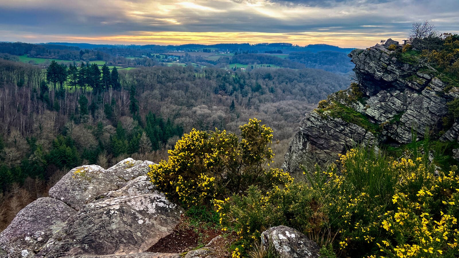 Paysage boisé et rocailleux au coucher du soleil depuis un sommet en Suisse Normande.