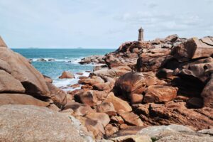Vue sur le phare de Ploumanac’h entouré de rochers de granit rose en Bretagne