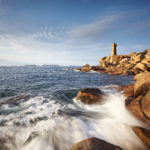 Photo de la côte de Granit Rose avec le phare de Mean Ruz en arrière plan