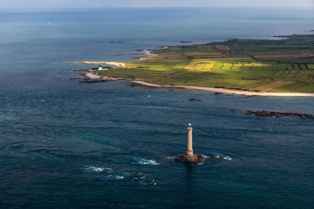 Phare de Goury au large du Cotentin entouré de champs et de mer