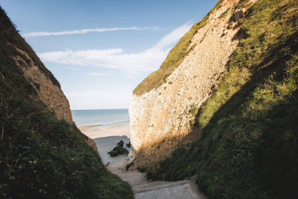 Chemin descendant vers une valleuse et une plage de galets typique du GR21, entre Fécamp et Étretat.