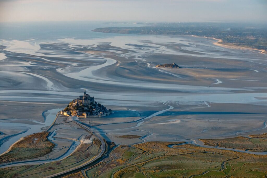 Vue aérienne rapprochée du Mont Saint-Michel entouré de la Baie