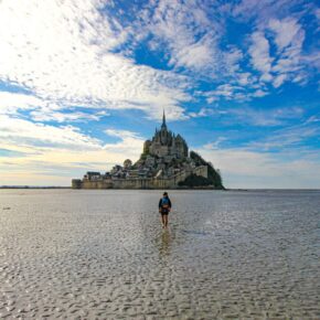 Randonneur traversant la baie du Mont Saint-Michel à marée basse