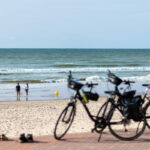 Couple de cyclistes à l'arrêt sur une plage de la Côte d'Opale