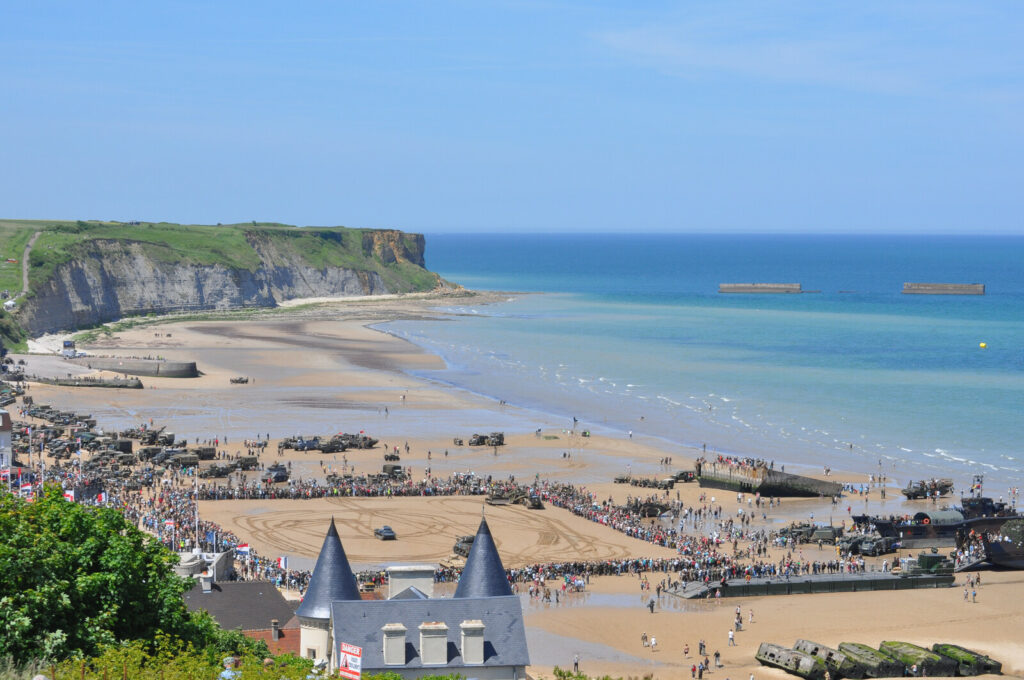 Commémorations du débarquement sur la plage d'Arromanches avec falaises en arrière-plan