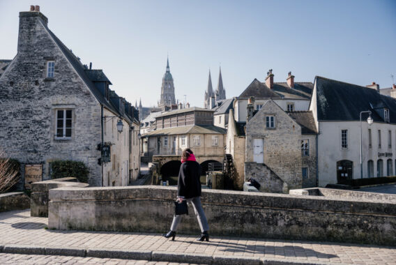 Femme marchant dans les rues anciennes de Bayeux avec la cathédrale en arrière-plan