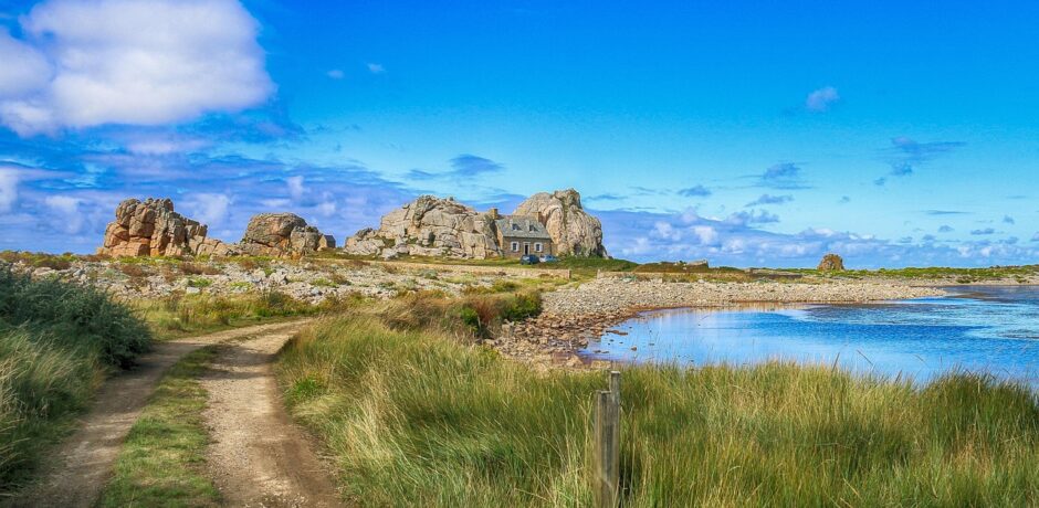 Sentier côtier menant à une maison entre les rochers au bord de la mer dans les Côtes d’Armor, Bretagne