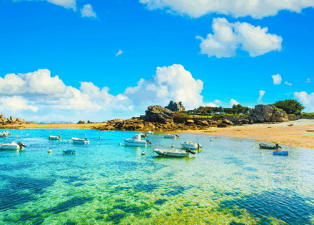 Randonneurs marchant sur le sentier côtier au milieu des immenses rochers de Trégastel sur la Côte de Granit Rose.