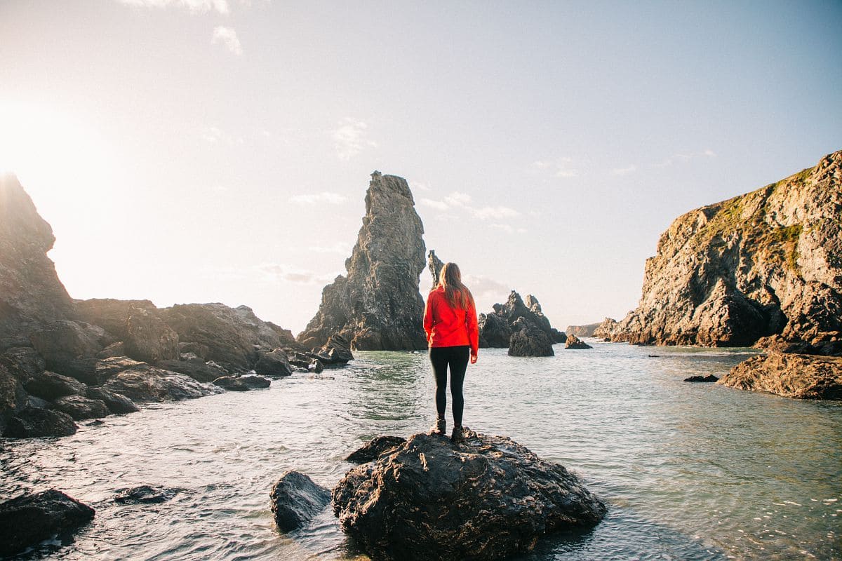 Une randonneuse devant les aiguilles de Port Coton à Belle île en Mer