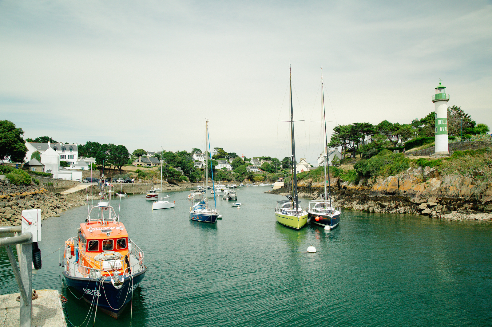 Vue sur le port de Doëlan avec ses voiliers et son phare vert, Finistère Sud.