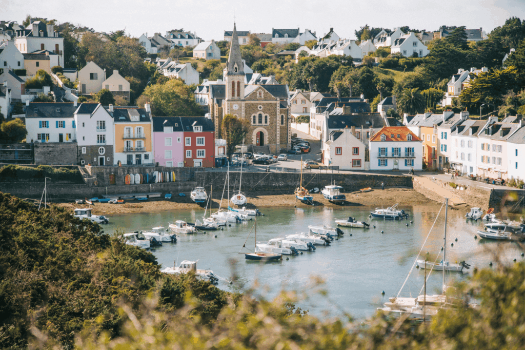 Le port pittoresque de Sauzon à Belle-Île-en-Mer avec son église, ses maisons colorées et ses bateaux au mouillage.