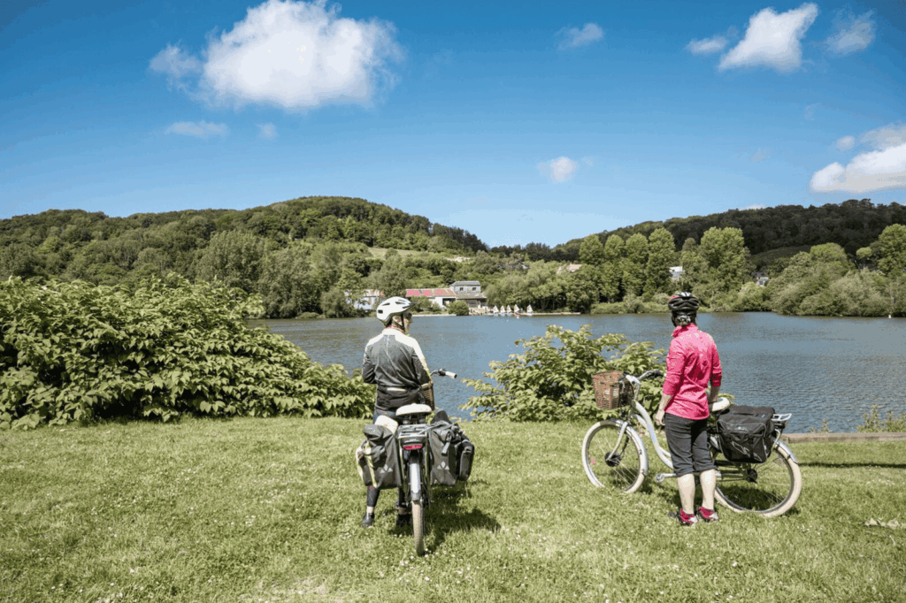 Deux cyclistes font une pause devant l'étang du Nid de Verdier à Fécamp.