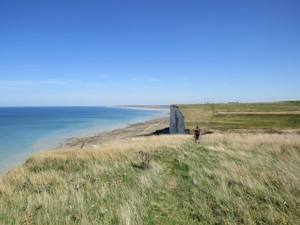 Un randonneur qui marche sur le sentier côtier surplombant les falaises de la Baie de Somme