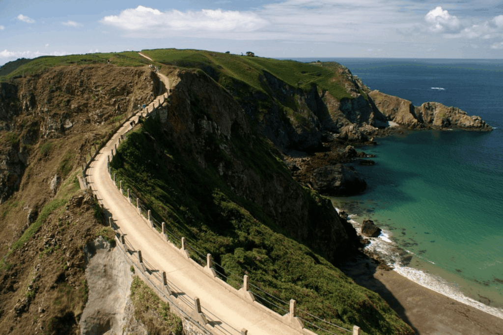 Sentier côtier spectaculaire longeant les falaises de Sercq avec vue sur l'océan turquoise, îles Anglo-Normandes