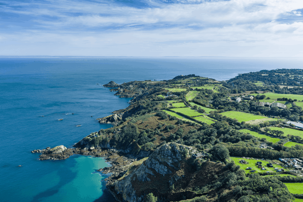 Vue aérienne de Bouley Bay à Jersey avec ses falaises verdoyantes, côte rocheuse et eaux turquoise