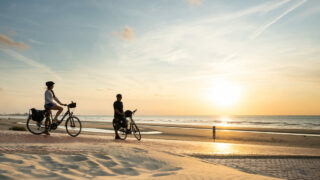 Cycliste profitant du couché de soleil sur les bords de plage du Hauts-de-France