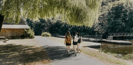 Trois randonneuses marchant à l'ombre d'un saule le long d'un canal en Bretagne par forte chaleur