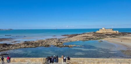 Promeneurs sur les remparts de Saint-Malo face au Fort National à marée basse